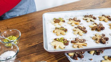 Dikkatlice paketlenmiş Noel kurabiyeleri, çikolataya batırılmış ve şeffaf selofan ambalajla sunulmuş, bayram hediyesi olarak mükemmel..