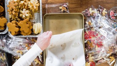 Düz yatıyordu. Dikkatlice paketlenmiş Noel kurabiyeleri, çikolataya batırılmış, ezilmiş fındık serpiştirilmiş, ve şeffaf selofan ambalajla sunulmuş..