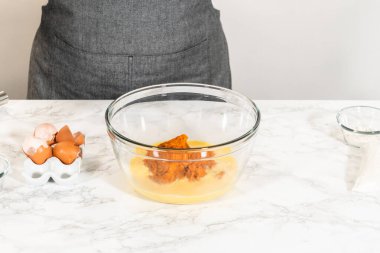 Sıcak bir mutfakta, büyük bir karıştırma kabı malzemelerin ustalıkla harmanlanması için sahne olur, kek karışımından nefis bir ev yapımı balkabağı pastası hazırlamak için sahne hazırlar.