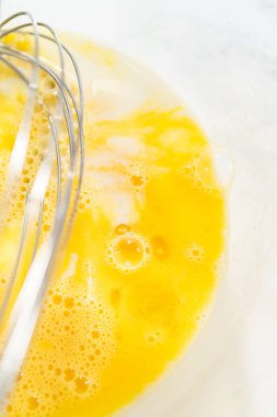 Ağız sulandırıcı ev yapımı balkabağı pastası için büyük bir karıştırma kabında ustalıkla harmanlanmış malzemelerin yakın çekimi..