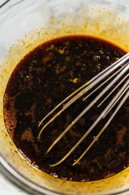 Koyu pekmez karışımı ile dolu bir kasenin içindeki çırpı çırpıcının yakın çekimi. Klasik Zencefilli Kurabiye Kurabiyesi Hamuru 'nun anahtar malzemesi. Şeker pekmezi bu bayram favorisine zengin bir renk ve derin bir tat katıyor..