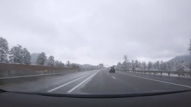 Denver, Colorado, ABD-26 Ocak 2024 - Karlı bir günde Denver 'dan Colorado Springs' e olan yolculuk devam ederken karla kaplı çam ağaçları I-25 'le huzurlu bir sürüş davet ediyor..