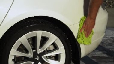 Denver, Colorado, ABD-1 Eylül 2023-Tesla Model 3, sonbahar yeşilliklerinin arka planına karşı bir konut yolunda titizlikle yıkanır..