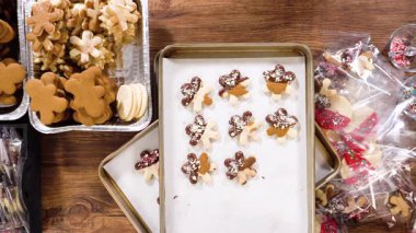 Düz yatıyordu. Dikkatlice paketlenmiş Noel kurabiyeleri, çikolataya batırılmış ve şeffaf selofan ambalajla sunulmuş, bayram hediyesi olarak mükemmel..