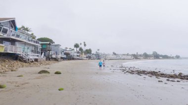 Kaliforniya, Miramar Sahili kıyılarında yürürken bulutlu kış gökyüzü sakin ve yansıtıcı bir atmosfer yaratır..