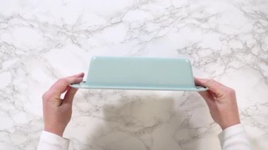 Castle Rock, CO, USA-006 - 18 Ocak 2025 - Beyaz mermer bir yüzeye yerleştirilmiş turkuaz seramik somun tavasının genel görünümü. Sahne minimalist ve iyi ışıklandırılmış, tavanın ortasında...