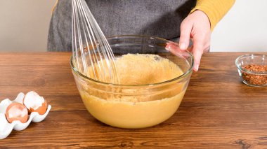 Bardak karıştırma kabında, büyük bir el çırpma ustalıkla lezzetli zencefilli kek ve karamel kremalı pasta malzemelerini karıştırır..