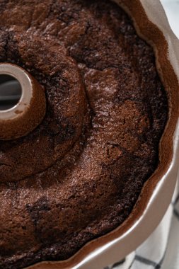 Chocolate Bundt Pastası dikkatlice tavadan çıkartılır. Yuvarlak soğutma rafına yerleştirilir. Kusursuz bir sunum ve hoş bir hoşgörü için hazırlanır..