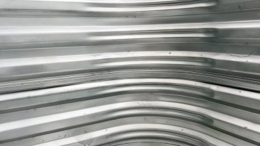 Tam bir iç görünüş yatay çıkıntıları ve metal bir pencere kuyusu duvarının yumuşak kıvrımlarını gösteriyor. Yüzey, küçük varyasyonlar ve açık gölgelerle eşit miktarda gümüşten oluşmuştur..