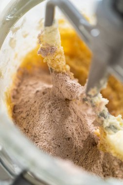 Kuru malzemeler karıştırma kabında kremalı karışıma ekleniyor, hamur oluşumu için karışmaya hazır..