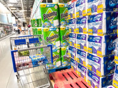 Parker, Colorado, ABD-20 Haziran 2025 - Bir alışveriş arabası büyük miktarlarda Bounty kağıt havlu ve banyo mendili paketlerinin yanında duruyor. Parlak mağaza ışıklandırması ürünü vurguluyor