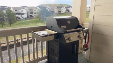 Parker, Colorado, ABD-11 Mayıs 2025 - Slow Motion video klibi Weber Spirit gaz ızgarasının kapağı kapalı temiz bir yan profilini yakalıyor. Izgara banliyöye bakan bir balkonda duruyor.