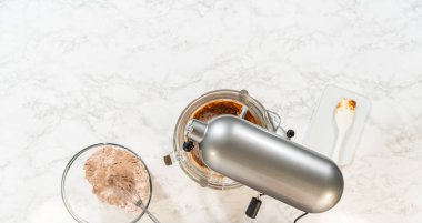 Çikolatalı Zencefilli Kurabiye Hamuru hazırlamak için kuru ve ıslak malzemeler içeren karıştırıcı ve kâseler hazırlayın. Tüm lezzetleri birleştiren karıştırma işlemi için kurulum hazır.