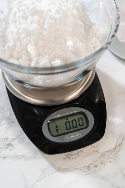 Ev yapımı krem peynir kreması için, pudra şekerini dikkatlice ölçmek zaruridir, tatlılığın ve kremalı dokuların mükemmel dengesini sağlar..