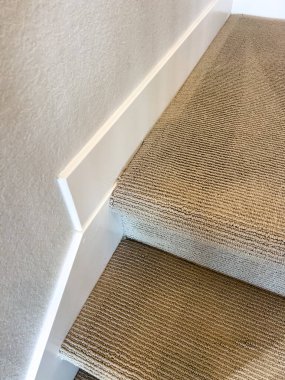 Bej halı sarılı merdiven izi ve merdiven basamakları aşırı yakın plan, derinlik ve doku gösteriyor. Ürün katalogları ya da yer döşemecileri için harika..