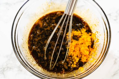 Portakal aromalı zencefilli kurabiye için pekmez ve yumurta karışımına portakal aromalı kurabiye eklendi. Parlak turuncu tat, pekmezin derin tadını dengelemek için ferahlatıcı bir narenciye verir..