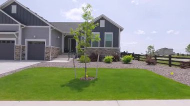 Parker, Colorado, ABD-30 Mayıs 2025 - Çimenlik ve çakıl arazisi olan yan yana banliyö evleri. Açık gökyüzünün altında beyaz bir SUV park halinde..