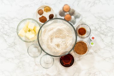 Denver, Colorado, ABD-22 Ekim 2024 Renkli Zencefilli Çörek Hamuru malzemeleri mermer bir tezgahın üzerine yerleştirilmiş. Un, tereyağı, esmer şeker, yumurta, baharat, akçaağaç şurubu, vanilya