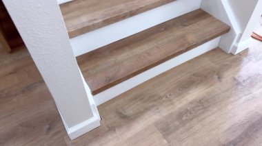 Bir kase spagetti, fırının üzerindeki kepçeyle domates sosuyla kaplanıyor. Pembe tişörtlü biri mutfak tezgahında yemek servisi yapar..