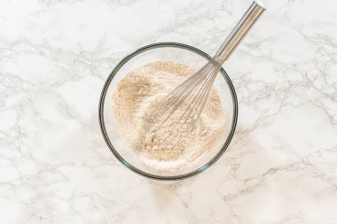 İçinde tarçın, zencefil ve kakao tozu bulunan bir kase un, lezzetli turuncu zencefilli kurabiye kurabiye hamuru tarifi için hazırlanmış. Baharatlar üstte katmanlı.