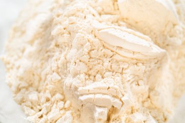 Unun aşırı yakın plan çekimi, ince dokusunu ve tozlu tutarlılığını yakalamak, Klasik Zencefilli Kurabiye Hamuru 'nun temelini oluşturmak için çok önemli..