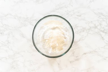 Cam bir kâseye karıştırılan malzemelerin yukarıdan çekimleri pürüzsüz, sade beyaz buz tabakası oluşturur..