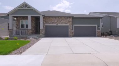 Parker, Colorado, ABD-30 Mayıs 2025 - Çakıl yolunda park etmiş kırmızı kamyonlu ve yeşil çimenli banliyö evlerinin ön görüntüsü. Sahne parlak ve temiz..