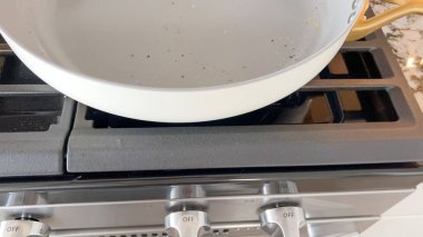 Gaz ocağında yemek kalıntısı olan yapışmaz bir tavanın detaylı görüntüsü. Mutfak kullanımını ya da mutfak malzemelerinin dayanıklılığını göstermek için harika.