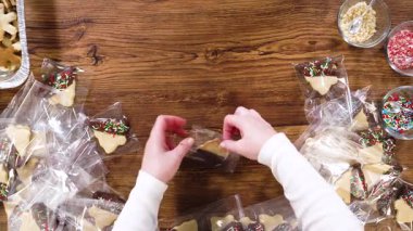 Düz yatıyordu. Dikkatlice paketlenmiş Noel kurabiyeleri, çikolataya batırılmış ve şeffaf selofan ambalajla sunulmuş, bayram hediyesi olarak mükemmel..