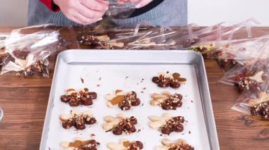 Dikkatlice paketlenmiş Noel kurabiyeleri, çikolataya batırılmış ve şeffaf selofan ambalajla sunulmuş, bayram hediyesi olarak mükemmel..