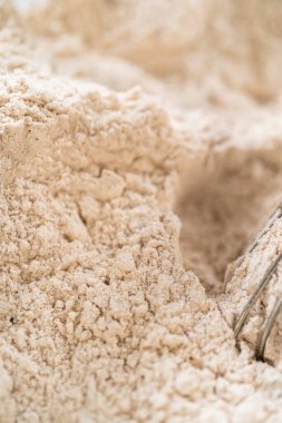 Baharatlı Zencefilli Kurabiyeli Kurabiye Hamuru 'nun kuru malzemelerinin yukarıdan görünüşü cam bir kasede çırpılmak için mükemmeldir. Un ve baharatlar bir araya getirilip, tek bir karışım oluşturulur.