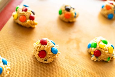 Parker, Colorado, ABD-1 Temmuz 2025 - Üzerine renkli şekerler konmuş üç kepçe kurabiye köftesi pişirme tepsisine konur. Odak, malzemelerin dokusunu ve renk karşıtlığını vurgular.