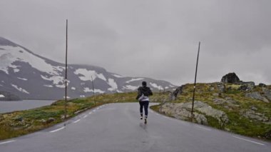 Norveç 'te yolda koşan bir adam Seyahat Yaşam Tarzı konsept macera tatili açık havada.