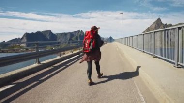 Norveç'te yolda bir sırt çantası ile mutlu kız gezgin, kuzey Avrupa'ya seyahat, macera yürüyüş otostop