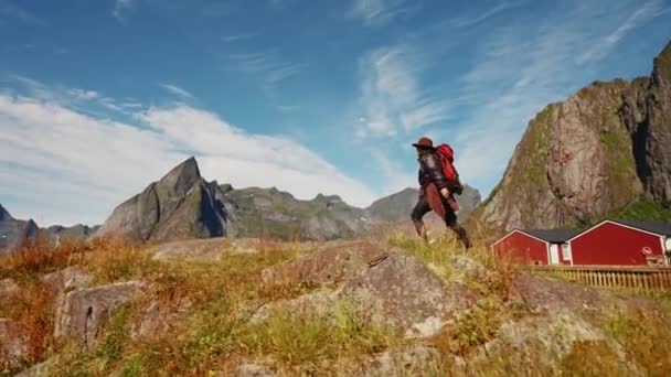 赤いバックパックを持つ女性旅行者のヒップスターは素晴らしい山と谷の景色で前進します — ストック動画