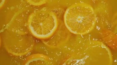 Dilimlenmiş limonlar, portakal ve limonların turuncu arka planda suya düşmesi, limonlu turunçgil meyvesi kokteyli yapmak, soğuk limonata içmek, dilimlenmiş meyveli karbonatlı su içmek,.