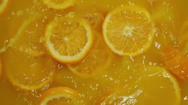 在橙色背景下 对落下来的切片荔枝 橙子和柠檬进行特写 使柑橘类水果混合在一起 喝冷饮柠檬水 用切片水果射击碳化水 — 图库视频影像