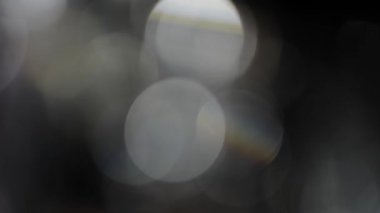 Bokeh of White Lights Siyah Arkaplan 'a sızıyor. Bokeh ve Doğal Işıklandırma Işıklarının Hareketi Bokeh Efekti