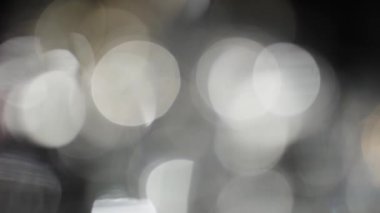 Bokeh of White Lights Siyah Arkaplan 'a sızıyor. Bokeh ve Doğal Işıklandırma Işıklarının Hareketi Bokeh Efekti