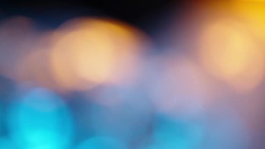 Mutlu Noel tatili için dekorasyon. Mutlu yıllar. Parıldayan Mavi ve Turuncu Yumuşak-Odaklı Işıklar yanıp sönüyor. Odaklanma özellikleri. Lens Bokeh. İşaret fişeği. Karanlık Arkaplan. Kapat.