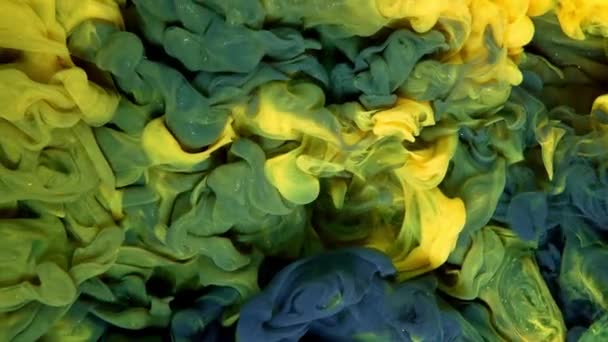 Groene Gele Verf Spetteren Elkaar Water Tegen Een Zwarte Achtergrond — Stockvideo