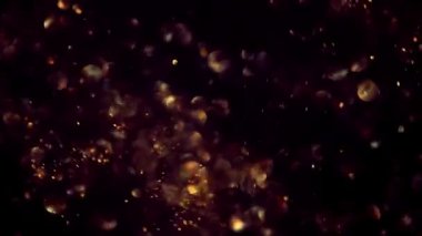 Altın parçacıklar soyut arka planda parlak altın rengi yüzen toz parçacıkları ile ağır çekimde Kara Arkaplan 'da parlıyor. Geleceği parlak sinek hareketi uzayda titreşiyor..