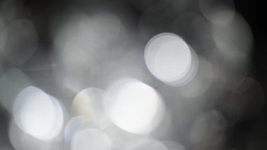 Bokeh of White Lights Siyah Arkaplan 'a sızıyor. Bokeh ve Doğal Işıklandırma Işıklarının Hareketi Bokeh Efekti