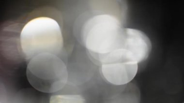 Bokeh of White Lights Siyah Arkaplan 'a sızıyor. Bokeh ve Doğal Işıklandırma Işıklarının Hareketi Bokeh Efekti