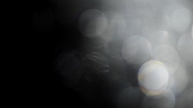 Bokeh of White Lights Siyah Arkaplan 'a sızıyor. Bokeh ve Doğal Işıklandırma Işıklarının Hareketi Bokeh Efekti