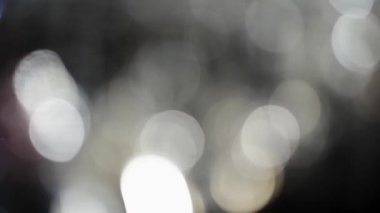 Bokeh of White Lights Siyah Arkaplan 'a sızıyor. Bokeh ve Doğal Işıklandırma Işıklarının Hareketi Bokeh Efekti