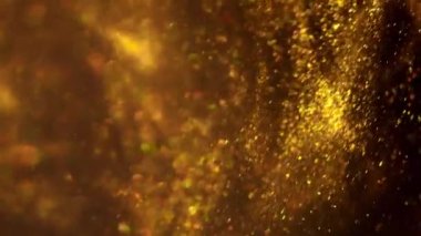 Altın parıltılı arka plan yavaş çekimde. Siyah zemin üzerinde rüzgarda uçan gerçek altın parçacıkları ile güzel bir geçiş, alanın derinliği ile çekilen. Altın tozu soyut arkaplan bokeh