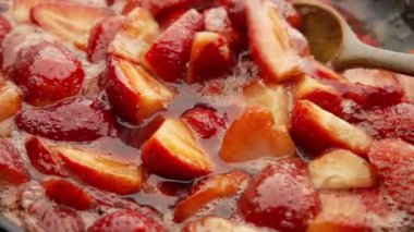 Çilek reçelini kendi suyunda yapma süreci. Açık bir kaseye şeker eklenmesi.