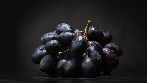 Grote Tros Druiven Met Druppels Water Een Zwarte Achtergrond Rotatie — Stockvideo