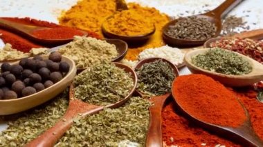 Baharat arka planı. Hindistan ve Asya yemek baharatları kaşıklarda ve karanlık arka planda. Hint mutfağının malzemesi olarak köri, biber, kırmızı biber.